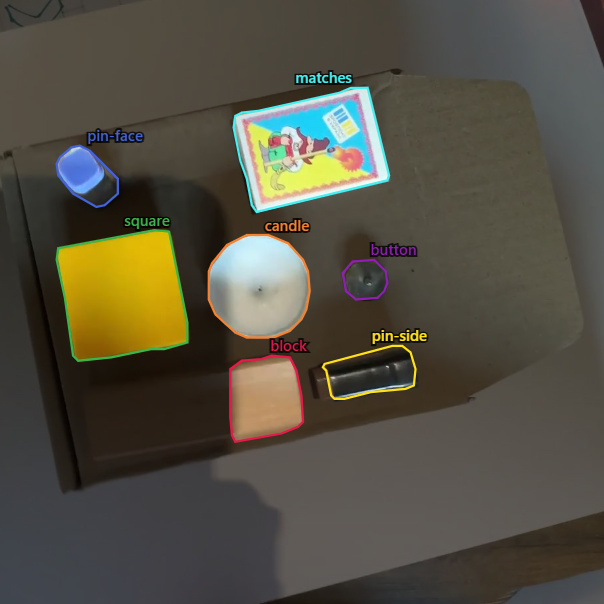 Cardboard fixture with labelled demo objects used for assembly-check iteration